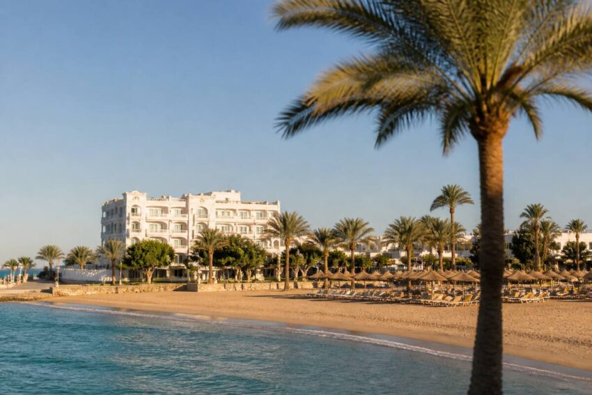 Zonnige kust met strand en hotel aan de boulevard, geschikt als uitgelichte afbeelding voor een blog over zonvakantie vergelijken